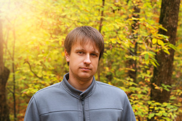 Portrait of young courageous man in autumn forest