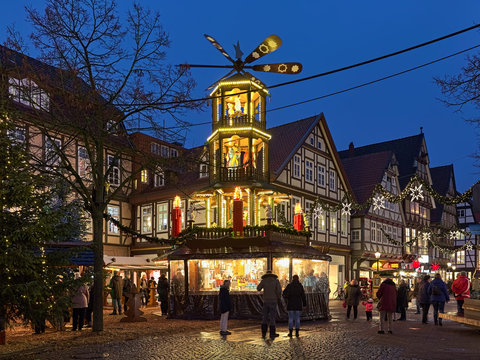 Celle, Germany. Christmas pyramid at Robert-Meyer-Platz and picturesque half-timbered houses at Poststrasse with Christmas illumination in Old Town in twilight.