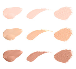 Set of different foundation shades on white background, top view