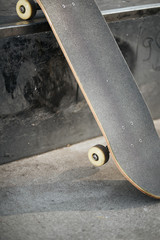 Closeup of skateboard in concrete skatepark on warm day