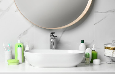 Roll-on deodorant and different toiletry on table in bathroom