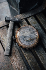 an old vintage hammer and a round bar of pine with sawdust on a bench. A wooden food stand for a master class. DIY concept.