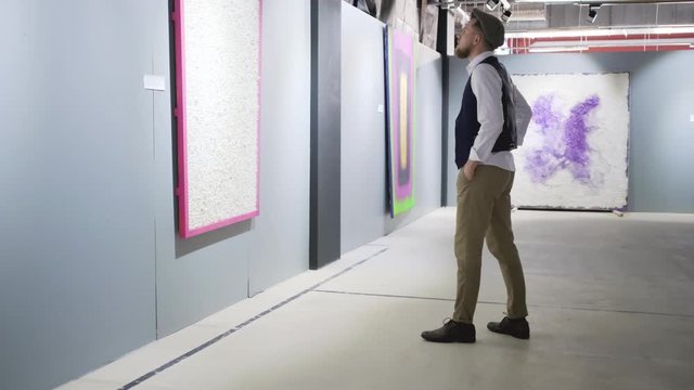 Man examining modern style artworks