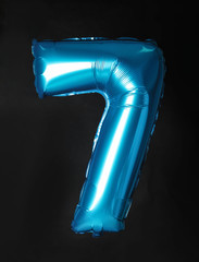 Blue number seven balloon on black background