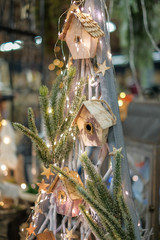 Bird houses on Christmas tree, lights on background, winter concept