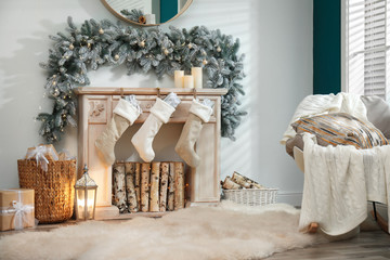 Fireplace with Christmas stockings in festive room interior