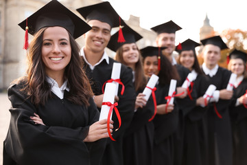 Fototapeta Happy students with diplomas outdoors. Graduation ceremony obraz