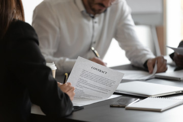 Female and male business partners sign contracts concept, closeup view