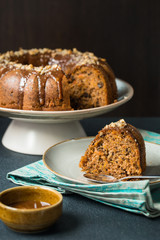 Pumpkin-carrot band cake with walnuts and caramel sauce. Homemade. On dark background.