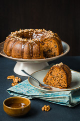 Pumpkin-carrot band cake with walnuts and caramel sauce. Homemade. On dark background.