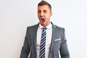 Young handsome business man wearing suit and tie over isolated background angry and mad screaming frustrated and furious, shouting with anger. Rage and aggressive concept.
