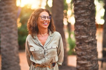 Middle age beautiful woman wearing glasses smiling happy and confident . Standing with smile on...