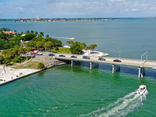 Fototapeta na wymiar Aerial view of open street bridge crossing ocean with small boat and linking Island Bay and Sarasota, Florida, USA