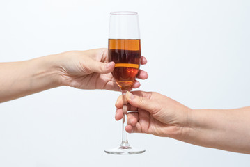 Female hand gives a glass with alcohol to another woman close up.
