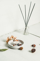 aromatherapy with dried seeds, incense  and candle on white wooden background
