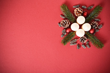 Seasonal greeting card concept with candles, pinecones and evergreen branches