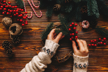 Top view of process preparation for christmas. Woman wear in winter sweater making hanmade...
