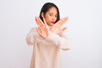 Young chinese woman wearing turtleneck sweater standing over isolated white background Rejection...
