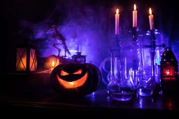 Halloween still-life background with different elements on dark toned foggy background. Selective...