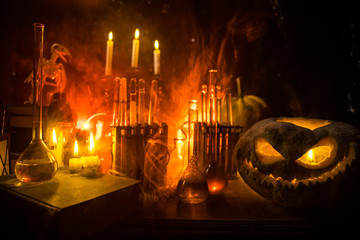 Halloween still-life background with different elements on dark toned foggy background. Selective...