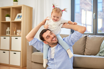 family, parenthood and fatherhood concept - happy father riding little baby daughter on his neck at home