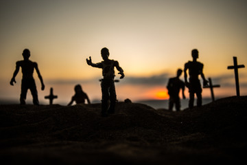 Fototapeta premium Silhouette some zombies on the cemetery walking around at sunset. Selective focus