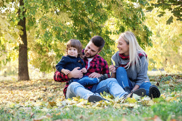 Happy parents playing with his adorable baby son.