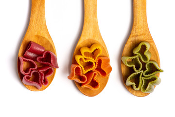 Colorful heart shaped pasta on wooden spoon
