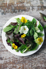 Healthy salad with flowers on a plate. Diet concept. Selective focus. Macro.