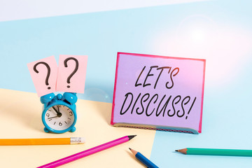 Conceptual hand writing showing Let S Discuss. Concept meaning asking someone to talk about something with demonstrating or showing Mini size alarm clock beside stationary on pastel backdrop