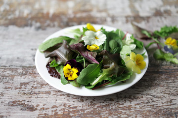 Healthy salad with flowers on a plate. Diet concept. Selective focus. Macro.