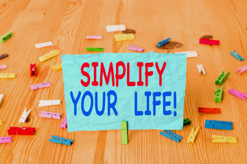 Word writing text Simplify Your Life. Business photo showcasing focused on important and let someone else worry about less ones Colored clothespin papers empty reminder wooden floor background office