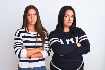 Young beautiful women wearing casual clothes standing over isolated white background skeptic and nervous, disapproving expression on face with crossed arms. Negative person.