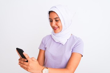 Young beautiful arabian girl wearing hijab using smartphone over isolated white background with a happy face standing and smiling with a confident smile showing teeth
