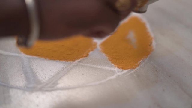 Colored sand or powder used decorate a floor, also known as rangoli used in Indian tradition .