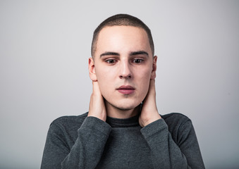 Fototapeta premium Feared unhappy crying man with shocked face with headache holding the head. Closeup studio portrait on grey background. Negative problem