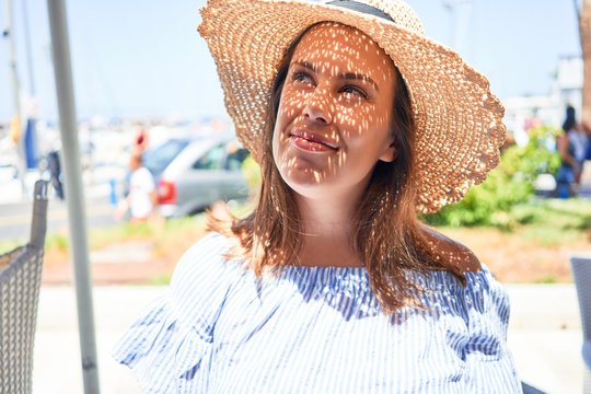 Young beautiful woman smiling happy walking on city streets on a sunny day of summer