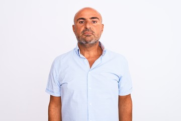 Middle age handsome man wearing casual shirt standing over isolated white background with serious...