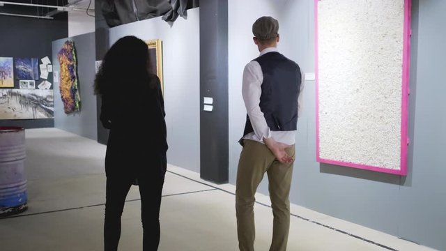Art gallery visitors having conversation about modern art