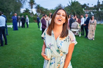 Fototapeta premium Young beautiful and elegant woman with wedding guest dress smiling happy and cheerful