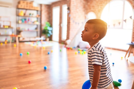 Beautiful toddler boy playing bowling at kindergarten