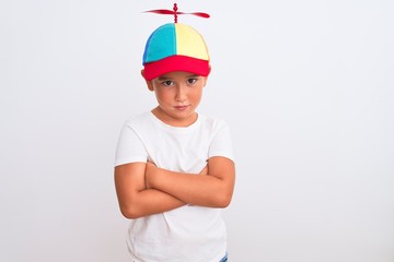 Beautiful kid boy wearing fanny colorful cap with propeller over isolated white background skeptic...