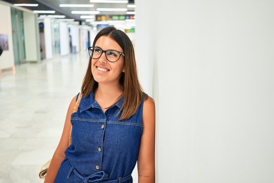 Young traveller woman at the airport going on vacation leaning on the wall