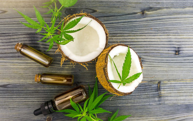 Fototapeta na wymiar Top view of a coconut and cannabis leaves and Hemp oils