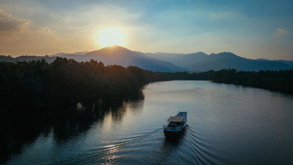 Beautiful Drone Shot of a Boat on the Prek Kampot River at Sunset during a River Cruise in Kampot, Cambodia.