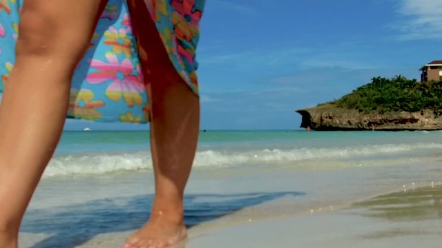 Woman's legs walking on the sunny beach in Varadero - Cuba