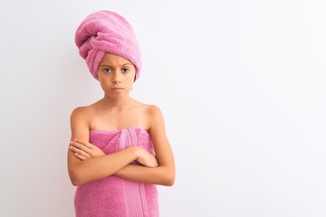 Beautiful child girl wearing shower towel after bath standing over isolated white background skeptic and nervous, disapproving expression on face with crossed arms. Negative person.