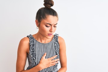 Beautiful woman with bun wearing casual dresss standing over isolated white background with hand on stomach because indigestion, painful illness feeling unwell. Ache concept.