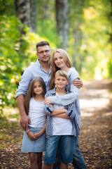 Fototapeta premium Family Group Standing Outdoors At Green Park In Autumn Landscape