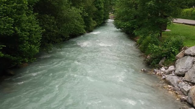 Flowing river from above in green forest.